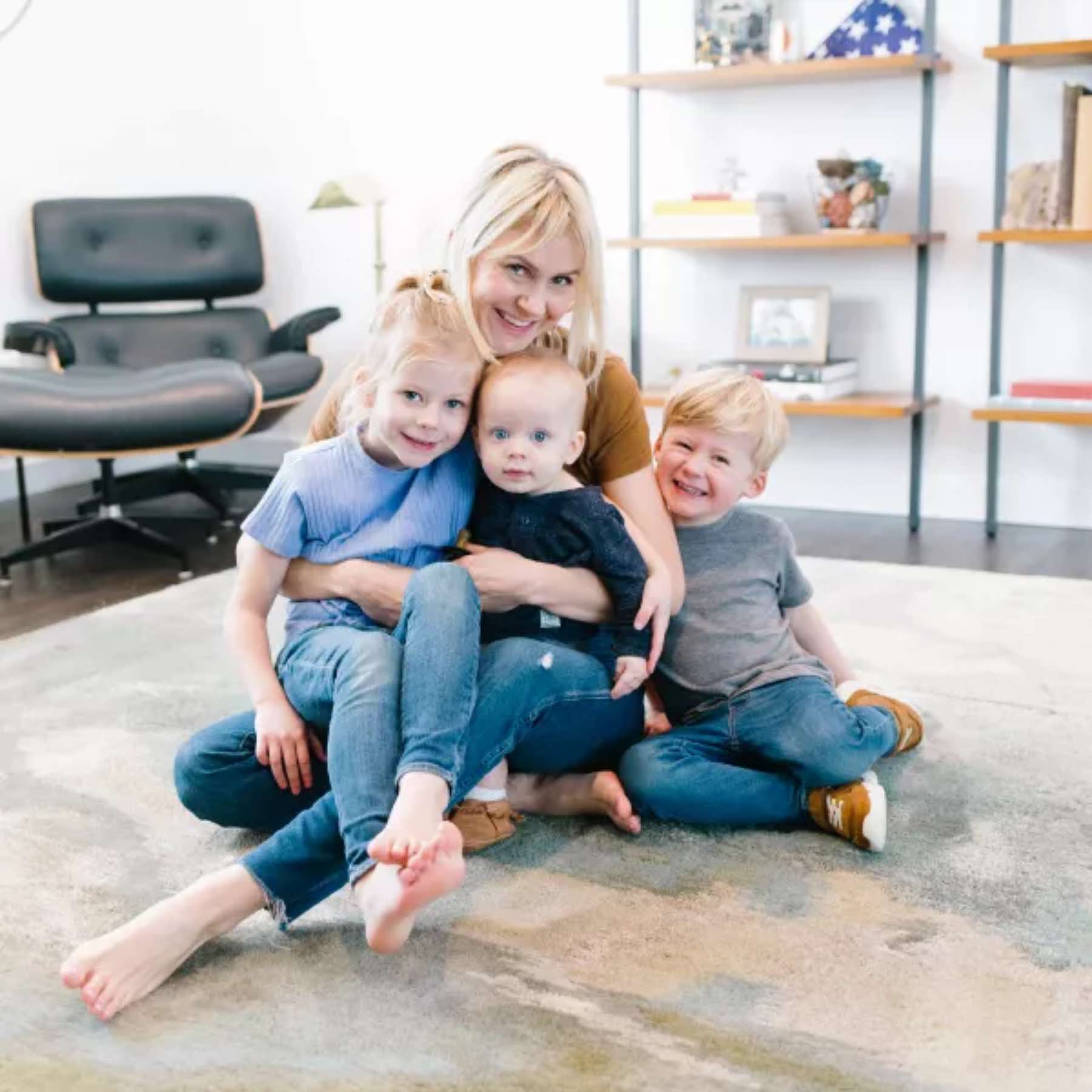A Zerorez Calgary family smiling and sitting on clean carpet.